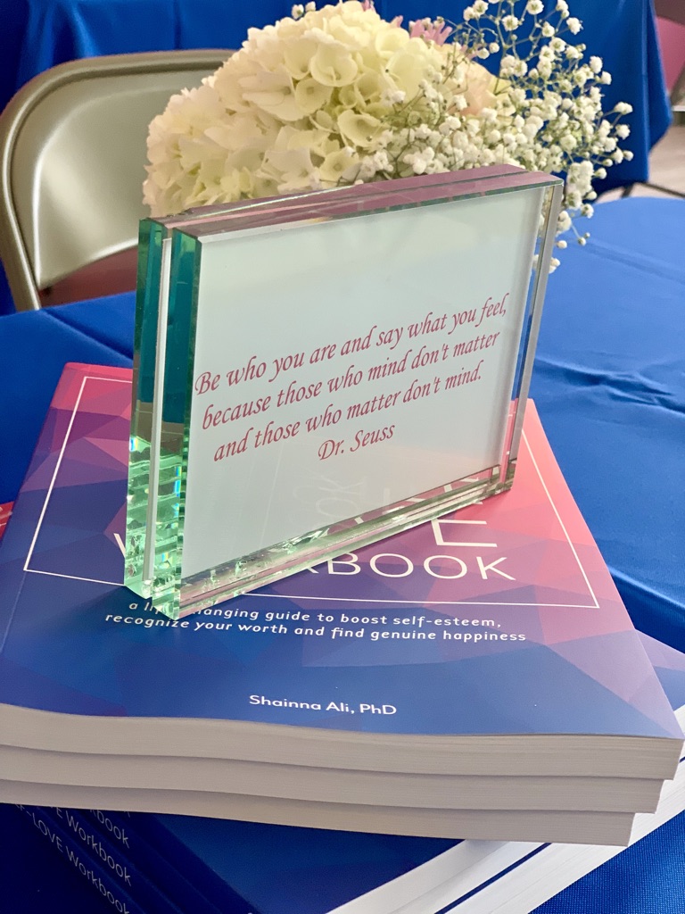 The Self-Love Workbook with a quote card and flowers