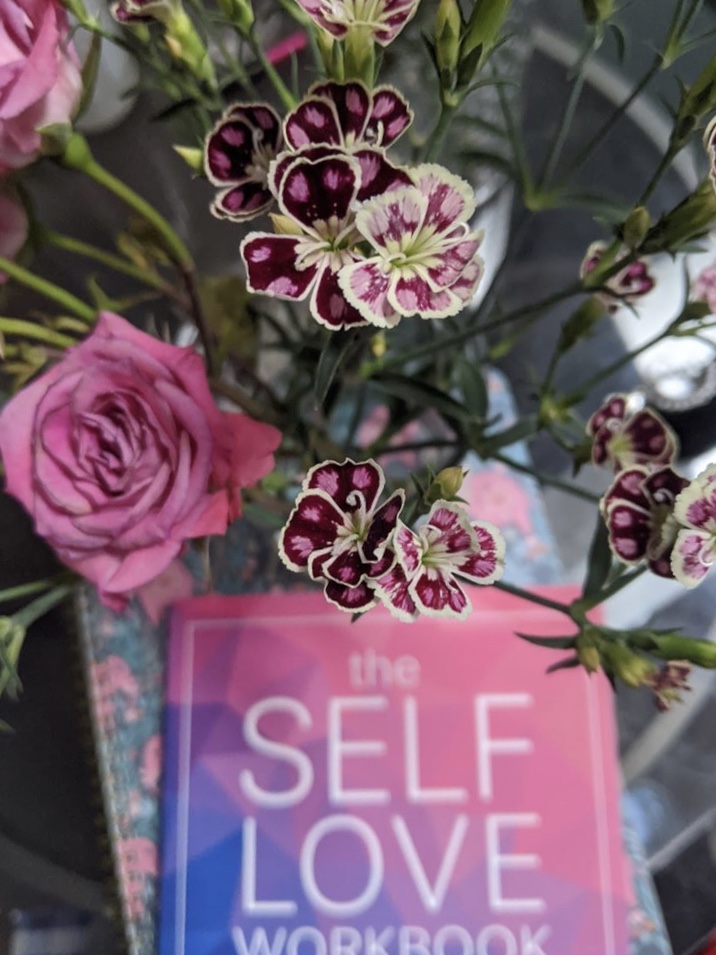 The Self-Love Workbook by Dr. Shainna Ali styled with flowers