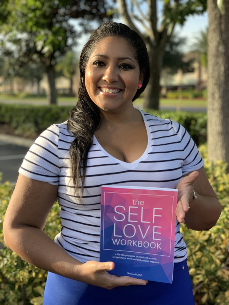 A reader holding The Self-Love Workbook